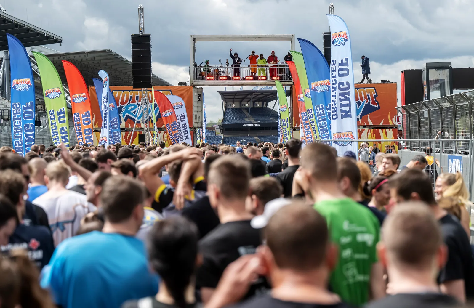 Großer Startbereich eines Hotfoot Run mit Teilnehmenden, Bühne und Markeninszenierung