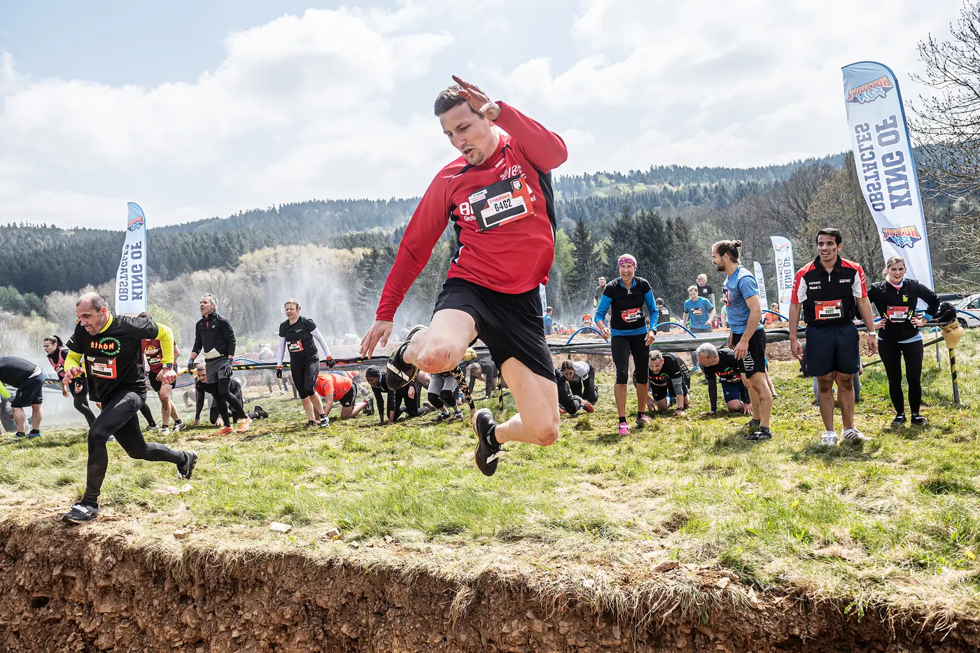 Teilnehmer springt beim Hotfoot Run über einen Graben
