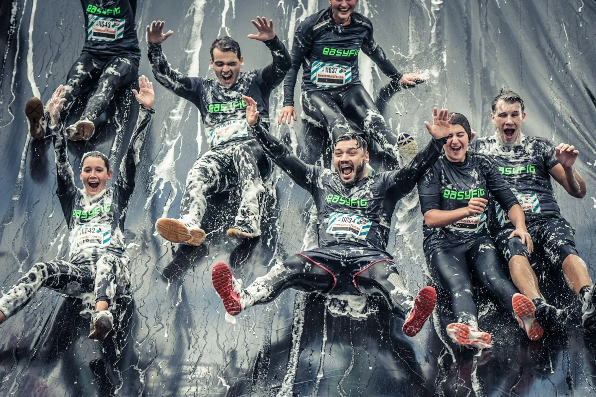 Firmenteam gemeinsam auf einer Schaumrutsche
